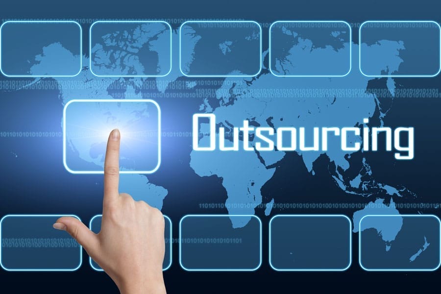 A hand is pointing to a digital button on a futuristic, blue background with a world map. The word Outsourcing is prominently displayed over the map. Multiple rectangular buttons surround the map, suggesting a global network interface.