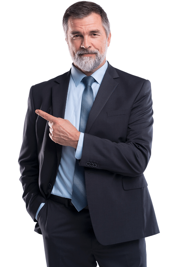 Testimonial 5 A confident man with a beard wearing a dark suit and blue tie points to his left. His other hand is in his pocket, and he smiles slightly, standing against a plain background.