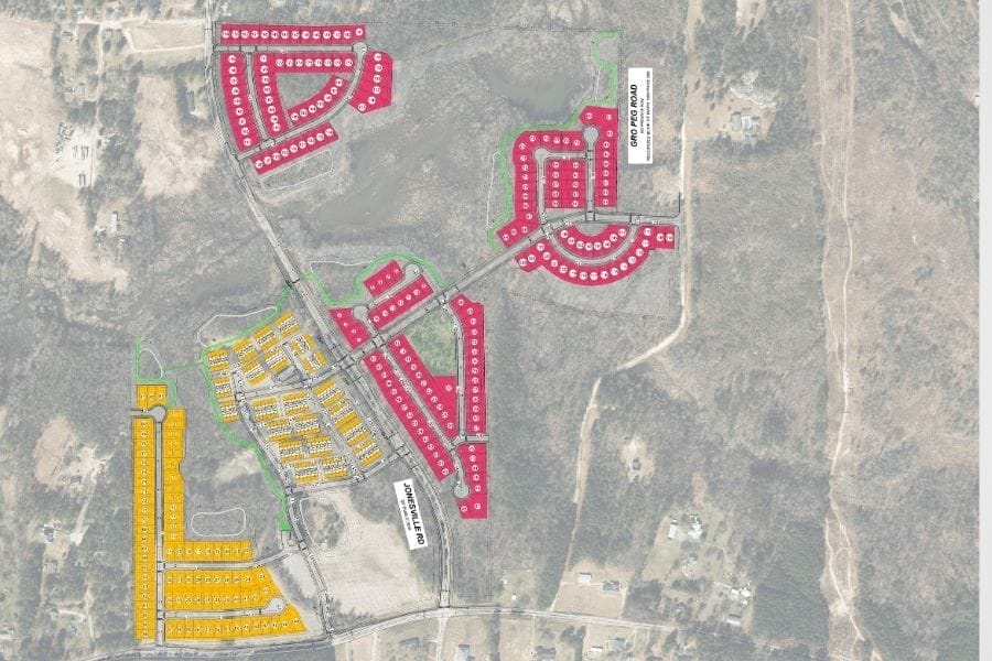 Aerial map displaying the Mitchell Mill Development plan with sections outlined in red, yellow, and green parcels. Roads intersect the area, surrounded by a rural landscape. Labels indicate street names and development phases of this sustainable infrastructure project.