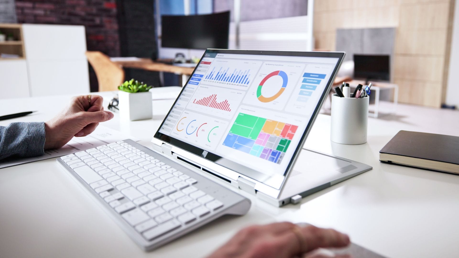 A person working on a laptop at a desk, focusing on analyzing Key Performance Indicators (KPIs).