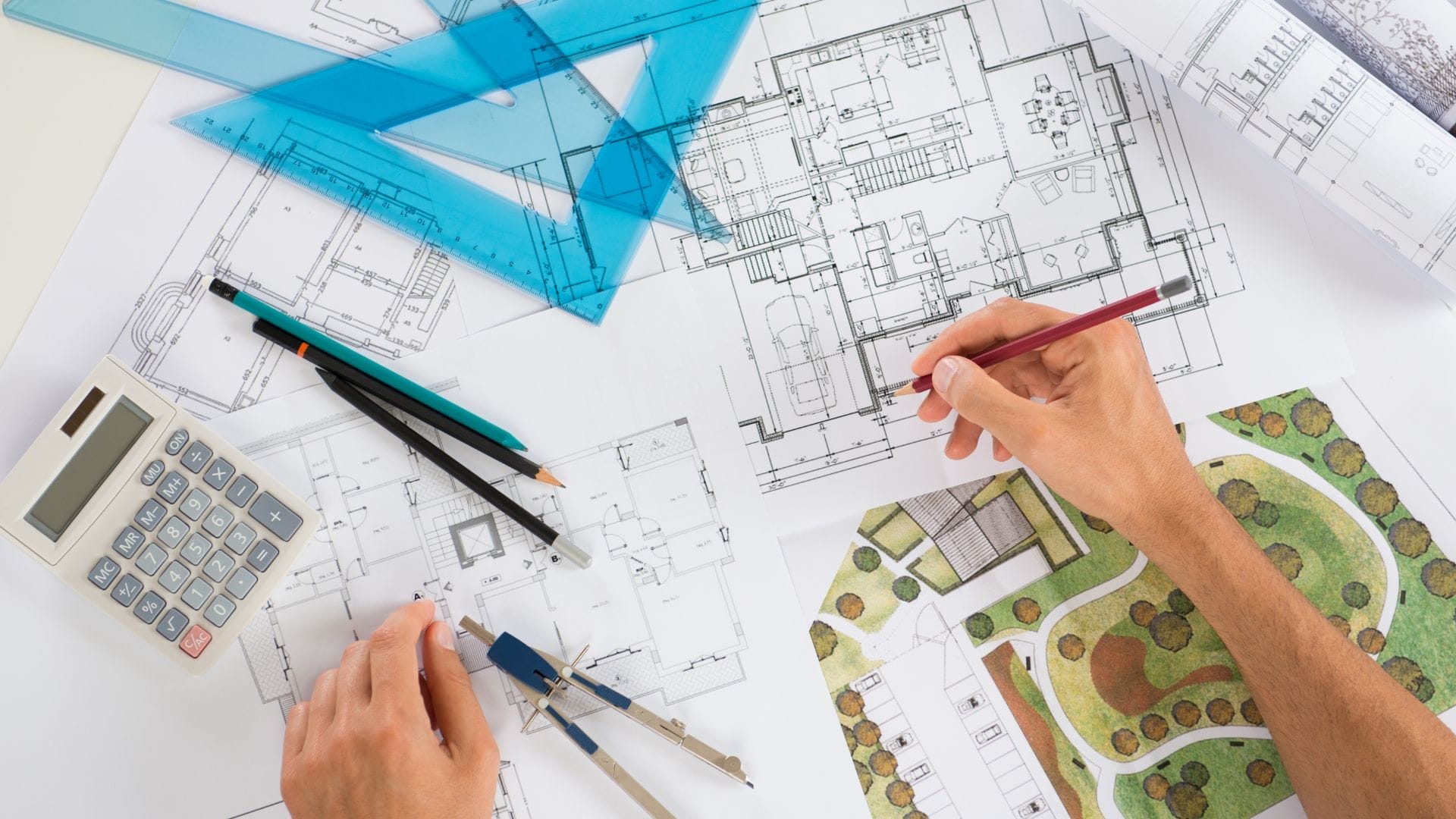 A person is meticulously working on architectural blueprints for a civil engineering projects with a red pencil. Various drafting tools, such as a compass, ruler, set squares, and calculator, are scattered around the plans. A landscape design is partially visible on the right.