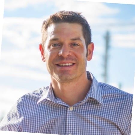 Civil Engineering Outsourcing A man with short brown hair in a checkered shirt smiles outdoors, exuding the confidence of a civil engineering outsourcing expert.