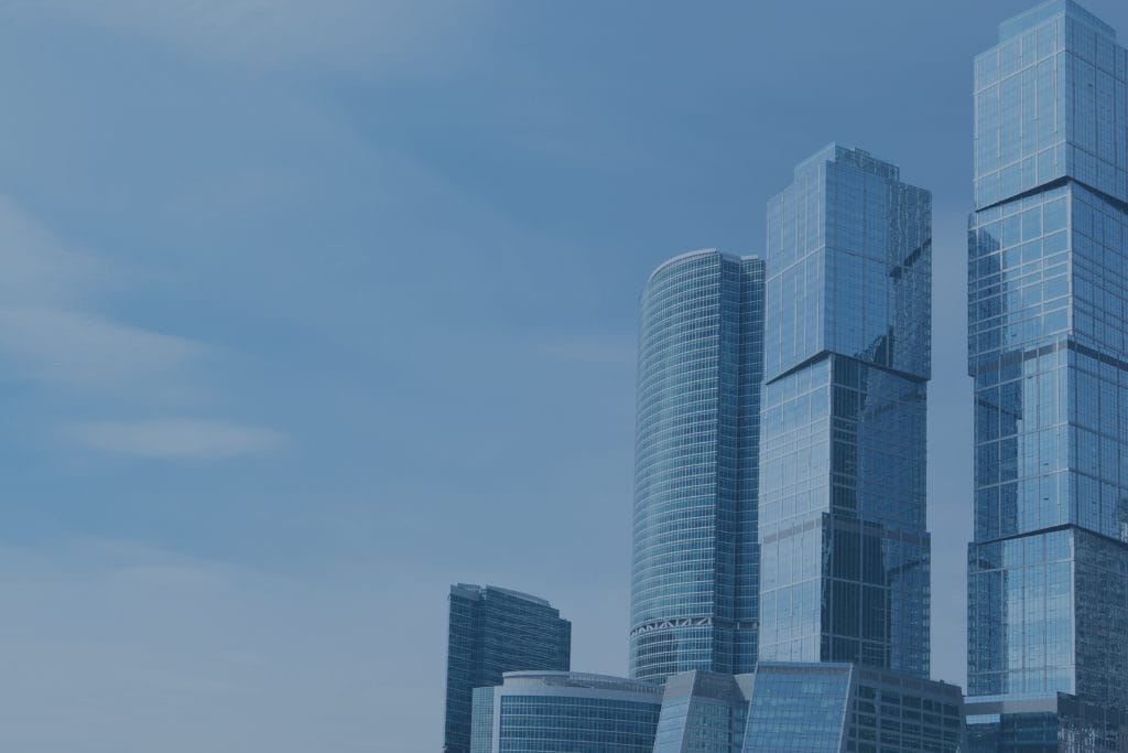 Civil Engineering Outsourcing Modern skyscrapers with glass facades reflect the blue sky, highlighting civil engineering outsourcing through diverse tower shapes.