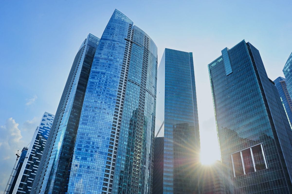 Civil Engineering Outsourcing Modern glass skyscrapers reflecting sunlight under a clear blue sky, symbolizing civil engineering outsourcing in an urban cityscape.
