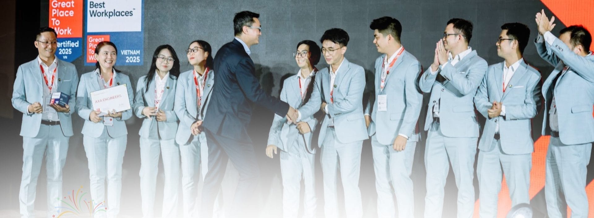 Civil Engineering Outsourcing Civil engineering outsourcing team in light gray suits, including AXA Engineers, receives awards on stage before Vietnam 2025 banners.