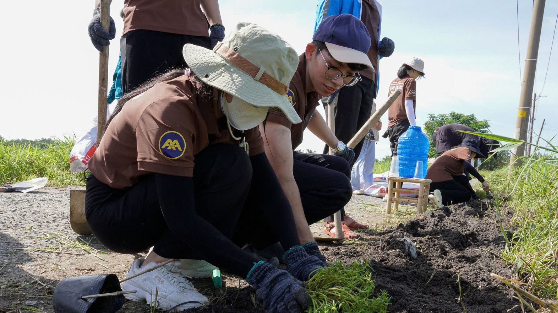 Civil Engineering Outsourcing A team in brown shirts, hats, and gloves work together along a dirt path, highlighting teamwork like civil engineering outsourcing.