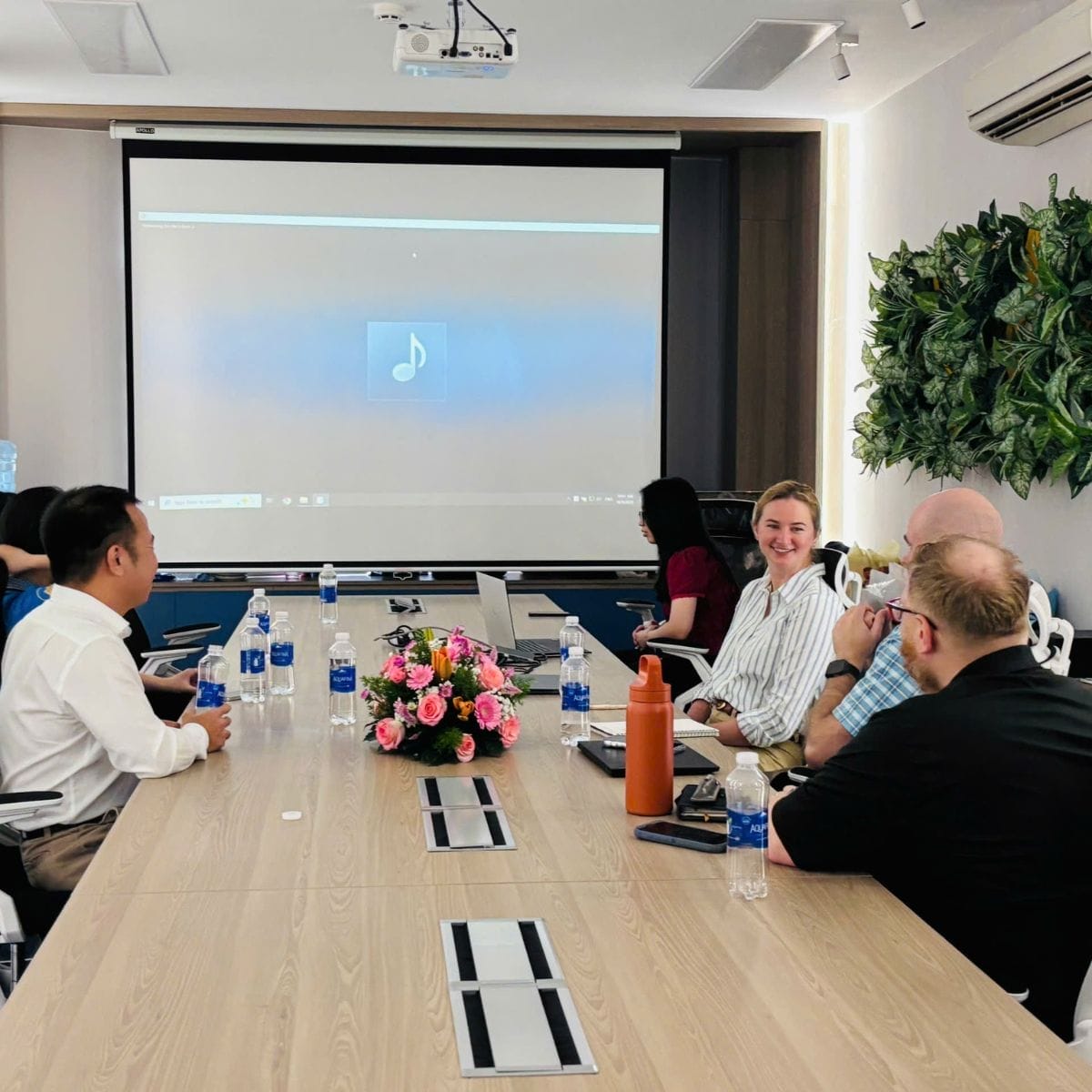 Civil Engineering Outsourcing During civil engineering outsourcing meetings, a group sits at a conference table with laptops, water bottles, and a floral centerpiece.