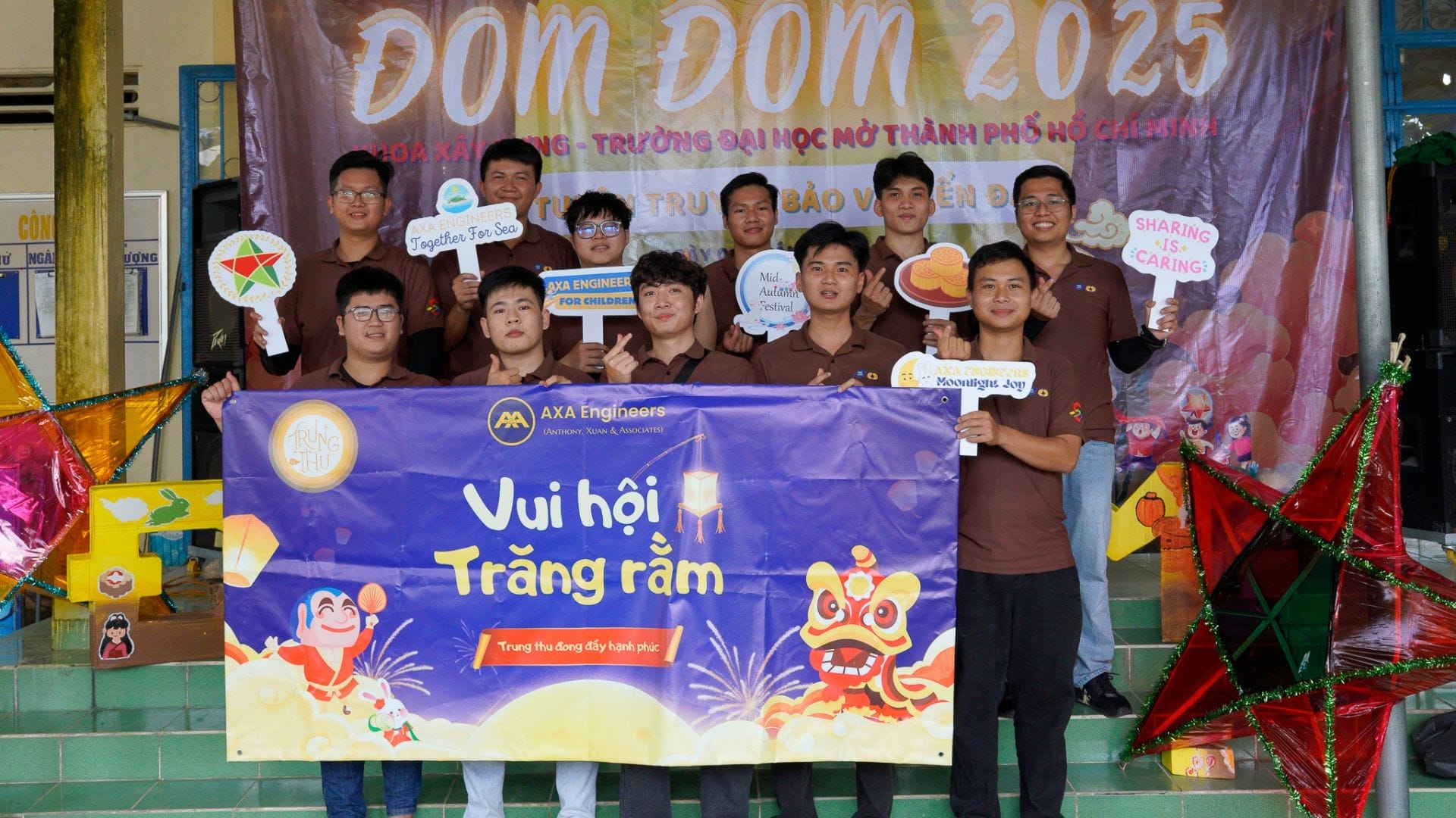 Civil Engineering Outsourcing A group of young volunteers in brown shirts pose with signs and a “Vui hội Trăng rằm” banner at a civil engineering outsourcing event.