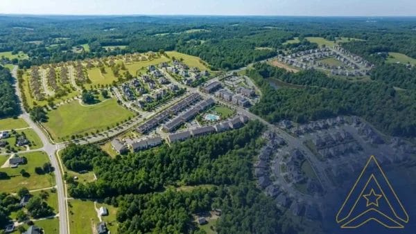 Civil Engineering Outsourcing Aerial view of Mitchell Mill Development, featuring civil engineering outsourcing in sustainable infrastructure amid houses, roads, greenery, and forests.