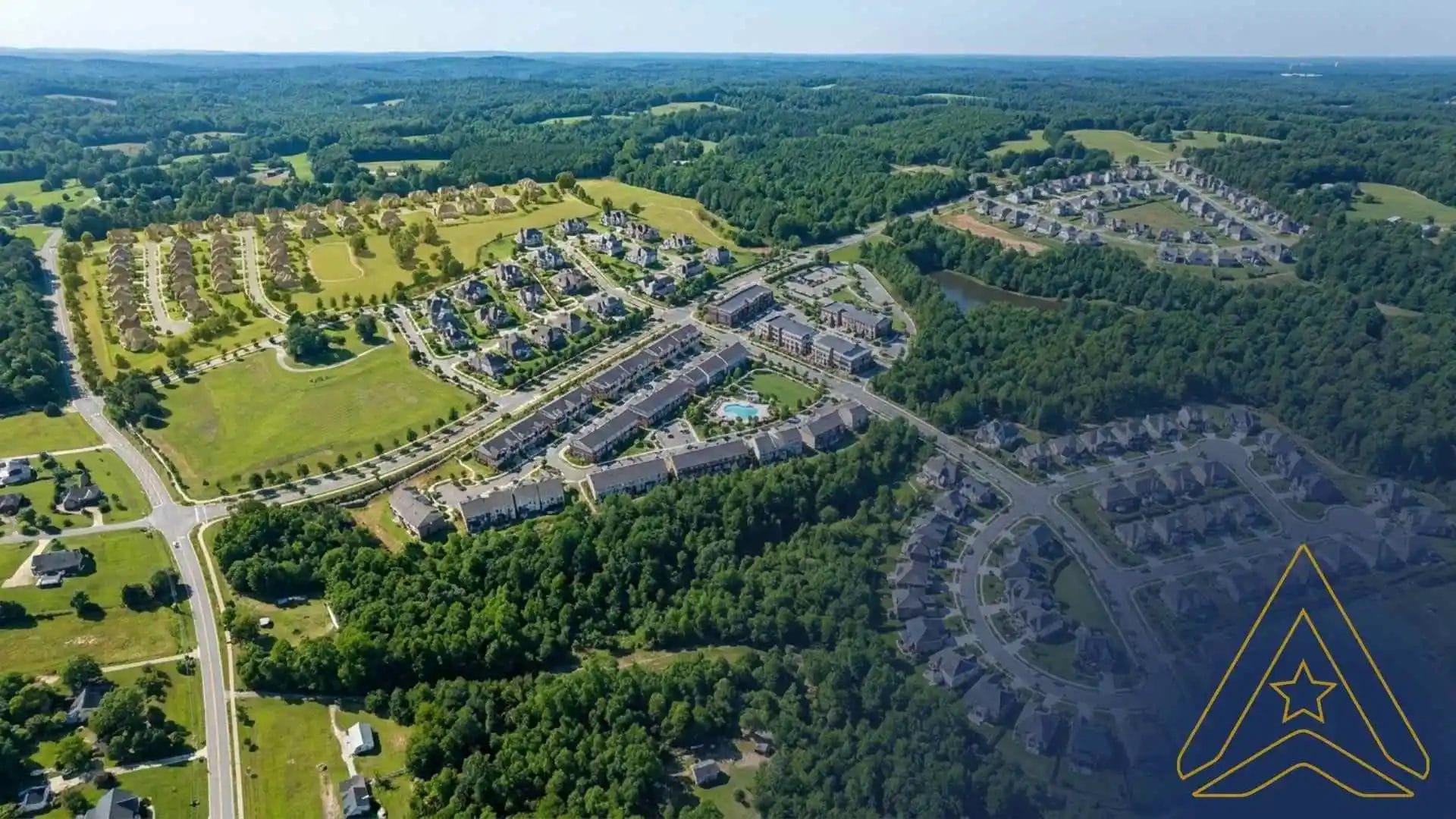 Civil Engineering Outsourcing Aerial view of Mitchell Mill Development, featuring civil engineering outsourcing in sustainable infrastructure amid houses, roads, greenery, and forests.