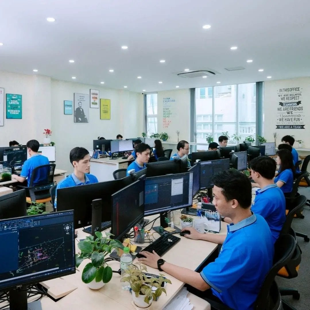 Civil Engineering Outsourcing An open-plan office where teams in blue shirts work at computers, reflecting civil engineering outsourcing. Contact AXA Engineers.